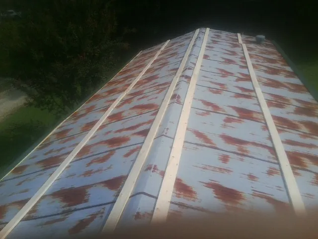 Rusted metal roof panels with new wood purlins before replacement — Storm Damage Roof Repair in Tarboro by Roofing Brothers
