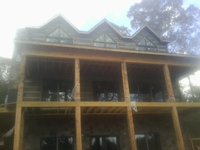 Dormers and porch framing on a large log home under construction — Roof Coating work by our crew in Tarboro