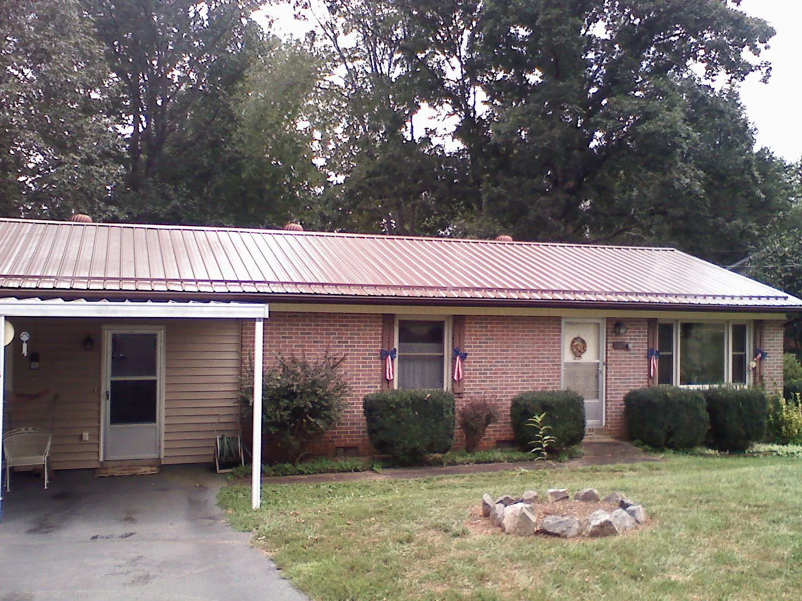 Bronze metal roof and carport on a brick ranch home — Roof Repair work by our crew in Tarboro